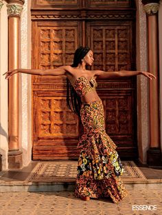 a woman standing in front of a wooden door with her arms outstretched and legs spread out