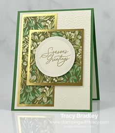 a close up of a greeting card on a white surface with green and gold trim