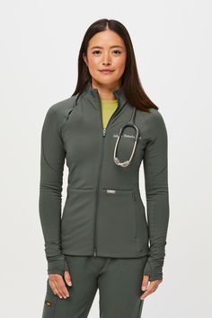 Why We Love ThisFeaturing eight pockets, a slim fit and lightweight, high-stretch, ultra-breathable fabric, the On-Shift™ Contourknit™ is the ultimate flex. Model Fit Description Model is 57.5' / Wearing S  Total of eight pockets Two concealed zipper hand pockets Two signature drop pockets at center front waist One stethoscope pocket at raglan seam with a concealed zipper Two interior drop pockets One interior security patch pocket  Slim fit Brushed interior Mock neck for insulation Center front Vest Layering, Figs Scrubs, Lab Coats, Scrub Pants, Model Fits, Outerwear Women, Outerwear Jackets