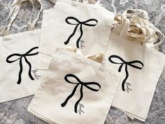 three white bags with black bows on them