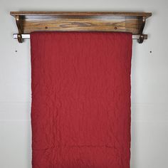 a red blanket hanging from a wooden rail