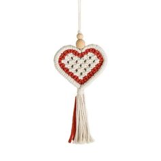 a white and red heart hanging from a string with a wooden bead decoration on it