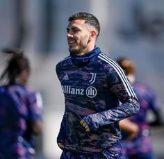 a soccer player smiles as he runs on the field