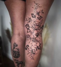 a woman's legs with tattoos and flowers on them, both showing their butts