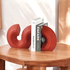 two books sit on top of a table next to a pair of red plastic letters