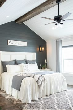 a bed room with a neatly made bed next to a window and a ceiling fan