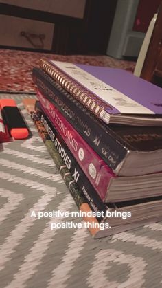 a stack of books sitting on top of a bed next to an american flag pillow