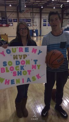 two people standing in a gym holding up a sign that says you're my son, i don't block my shot when he has