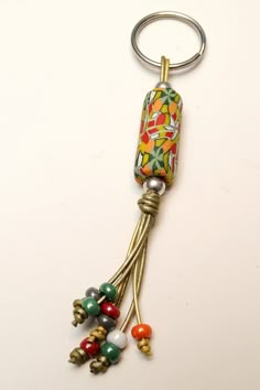 a keychain with beads hanging from it's side on a white surface