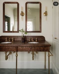 a bathroom with two sinks and mirrors on the wall