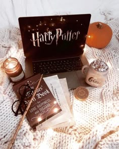 a harry potter laptop, books and candles on a bed