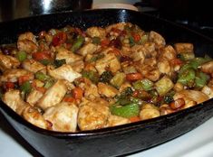 a pan filled with chicken and vegetables on top of a stove