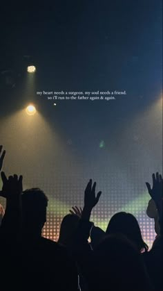 a group of people standing on top of a stage with their hands in the air