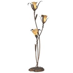 a lamp that is on top of a wooden base and has three flowers in it