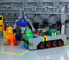 some legos are sitting on the floor in front of a large machine and other toys