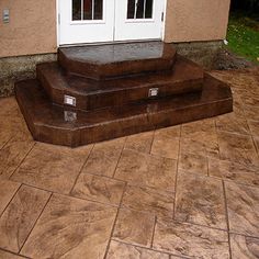 a dog is sitting on the front steps of a house that has been painted brown