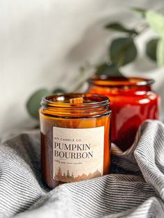 two jars of pumpkin bourbon sitting on top of a blanket