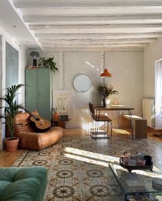 a living room filled with lots of furniture and plants on top of the floor next to a table