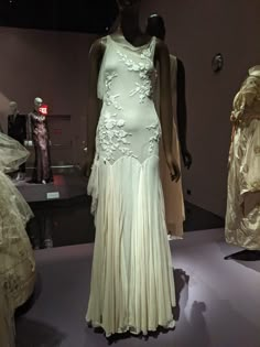 mannequins dressed in white dresses on display