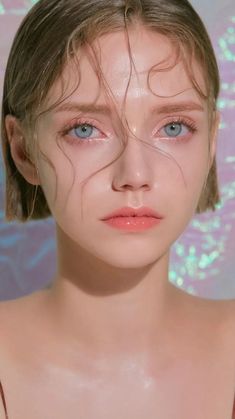 a close up of a person with water on her face and hair blowing in the wind