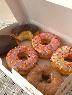 six donuts in a box with sprinkles on them