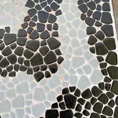 a close up view of a mosaic tile floor with black and white stones on it