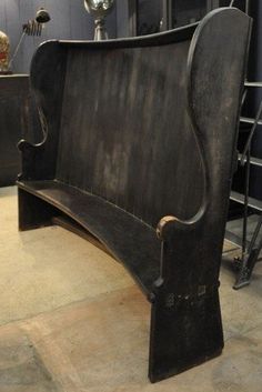 an old wooden bench sitting in a room next to other metal items on the floor