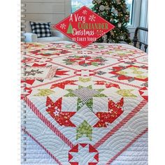 a very cozy christmas quilt on a bed with a tree in the background and a sign that says, merry country christmas