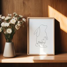 a vase filled with flowers next to a drawing