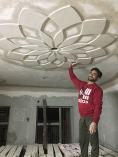 a man standing on top of a wooden floor in a room under construction with unfinished walls