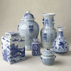 several blue and white vases are arranged on a table