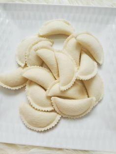 several pieces of food on a plate with white furnishing and some sort of scallop