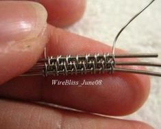 a person is holding two pins in their left hand and they are made out of metal wire