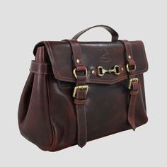 * H: 26cm W: 16cm L: 38cm.  * A beautiful Emma Satchel Handbag is crafted from Buffalo leather.  * Will only get softer as it is used.  * The top handle is perfect to carry in your hand.  * An adjustable and detachable shoulder strap.  * Fastens to the front with 2 brass buckles.  * Embossed with the Grays 1922 logo to the front.  * Fitted with a Snaffle-bit Fitment.  * Inside there is large main compartment with a zipped pocket, phone holder and a key compartment.  * Protective brass feet to th Working Spaniel, Snaffle Bit, Hot Water Bottle Cover, Very Cute Dogs, Satchel Handbag, Hunting Clothes, Buffalo Leather, Brass Buckle, Satchel Handbags