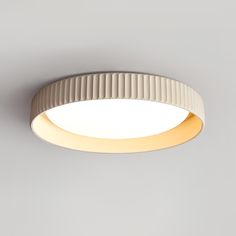 a white circular light fixture on a gray wall