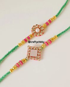 two necklaces with beads and stones on green string, one in gold and the other in pink