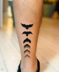 a person with a tattoo on their leg that has birds flying in the sky above them