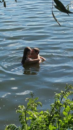 two people are swimming in the water with their heads close to each other's backs