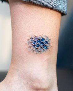 a woman's foot with a small tattoo on the side of her ankle,