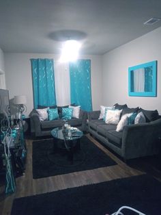 a living room filled with furniture and blue curtains