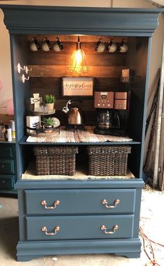 a blue hutch with baskets on the bottom shelf and lights above it in a room