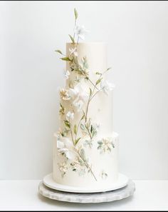 a three tiered cake with white flowers on it