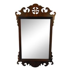 an ornate wooden mirror hanging on the wall