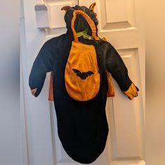 a stuffed animal hanging on the front door with an apron attached to it's back