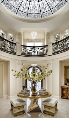 a large foyer with a glass dome ceiling and chandelier above the entryway