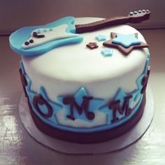 a birthday cake with a guitar and stars on the frosting is ready to be eaten