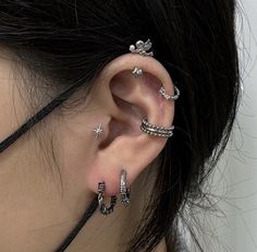 a close up of a person's ear with three different piercings on it