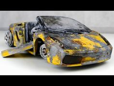 a yellow and black toy car with it's hood up