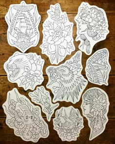 six stickers with designs on them sitting on top of a wooden table next to each other