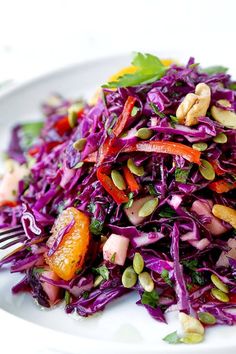 a white plate topped with red cabbage and nuts